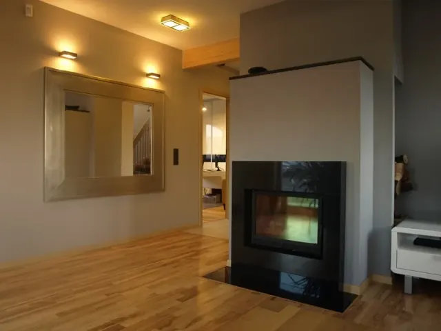Salon z kominkiem i drewnianą podłogą