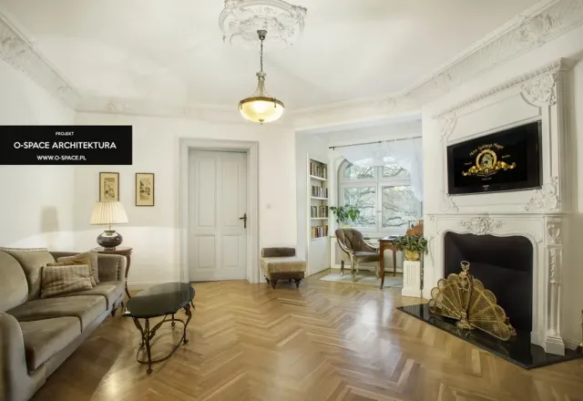 Salon z parkietem, kominkiem i dekoracyjnymi sztukateriami
